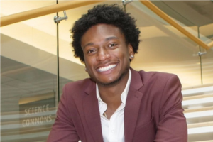 four people smiling in white lab coats, two shaking hands