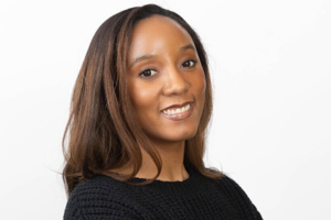 four people smiling in white lab coats, two shaking hands