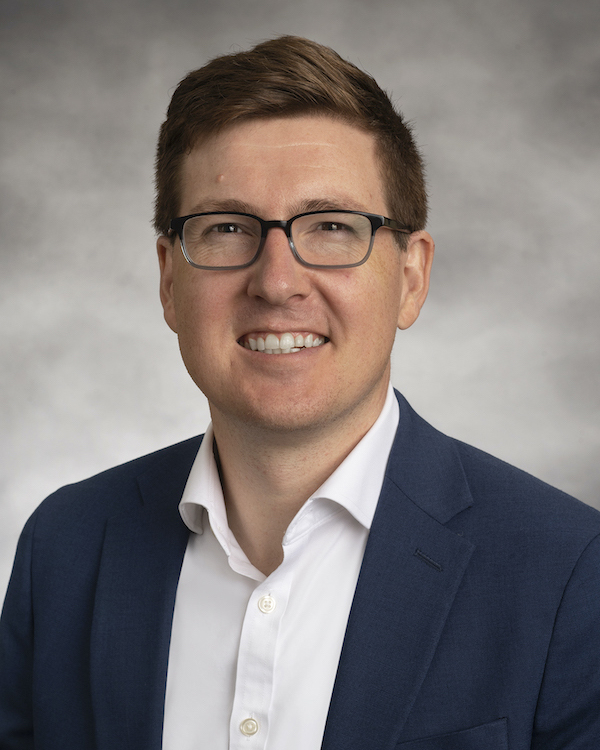 Portrait of Morgan Greenleaf in a dark blue jacket, smiling brightly