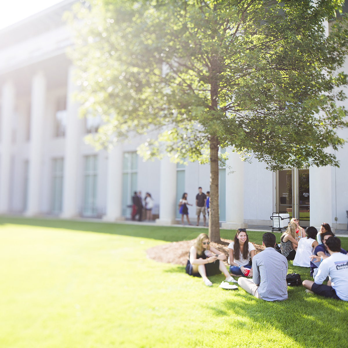 Emory students sitting on lawn in front of building