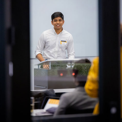 A young man speaking to an audience at The Hatchery innovation showcase