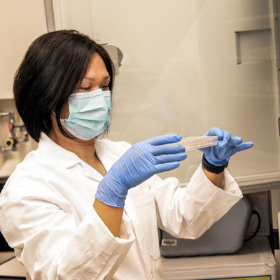 a medical researcher looking at a tray of samples in a lab